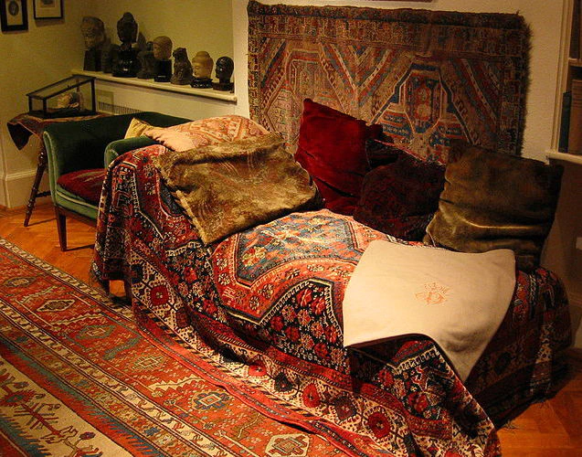 Image: Sigmund Freud’s couch in the Freud Museum London. The room features a floor carpet, wall carpet, couch carpet, and pillows. Photo credit: Robert Huffstutter (CC BY 2.0).