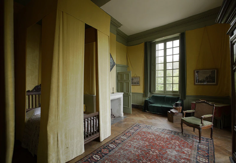 Image: Room in a late 16th-century French castle. It features bed hangings and wall hangings in the same color, a floor carpet, and window curtains. Photo credit: PMRMaeyaert (CC BY-SA 3.0).