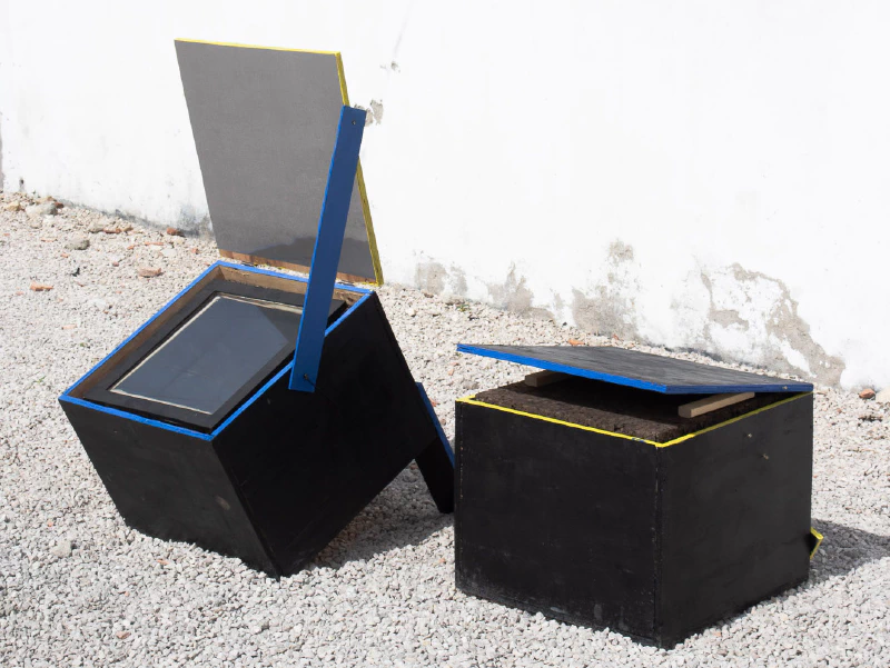 Image: Two conventional, non-electric solar box cookers. Solar energy enters the glass plate and heats up the interior. Built by Audrey Belliot (Slowlab) and Marie Verdeil. Photo by Marie Verdeil.