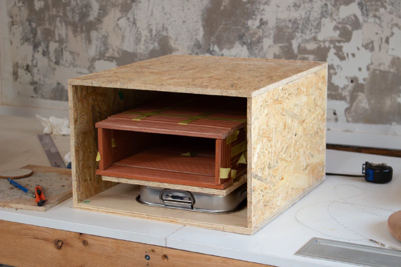 Image: The oven chamber inside the wood structure. The space in between will be filled up with cork insulation and a mortar layer at the bottom. Photo by Marie Verdeil.